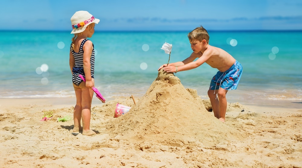 copii facand castel de nisip 